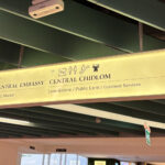 The Sign lit in yellow in Central CHitlom Pointing the Direction to BTS skytrain and Connectiong mall, Central Embassy.