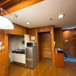 The kitchen and living area in a wooden cottage at Yunohara Hot Spring Auto Camping Ground.