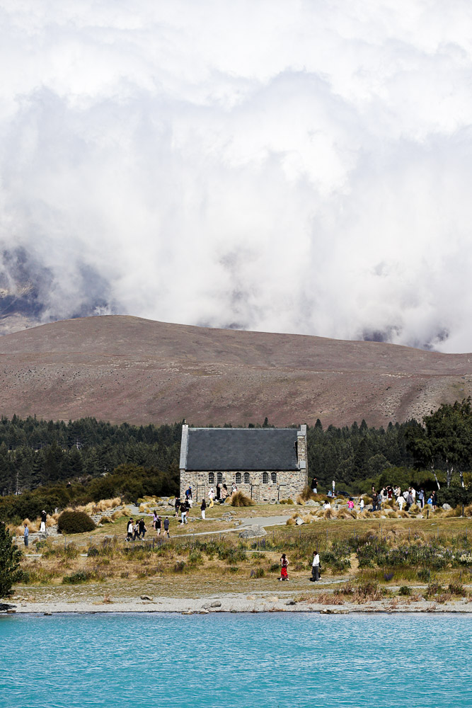 The Church of the Good Shepherd at Lake Tekapo in summer afternoon with a big cloud behind covering the mountains