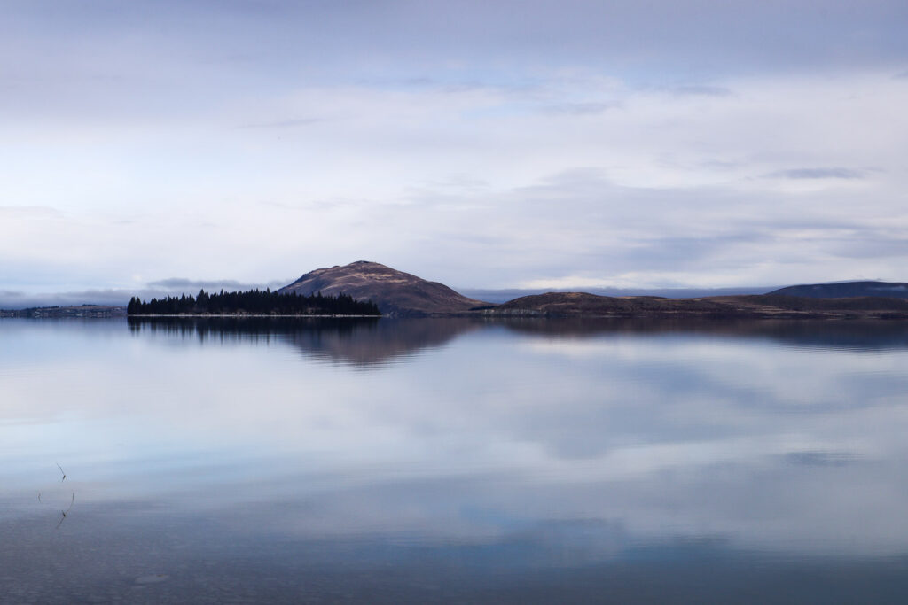 Evening at Lake Tekapo with Motuariki in the view with reflective water