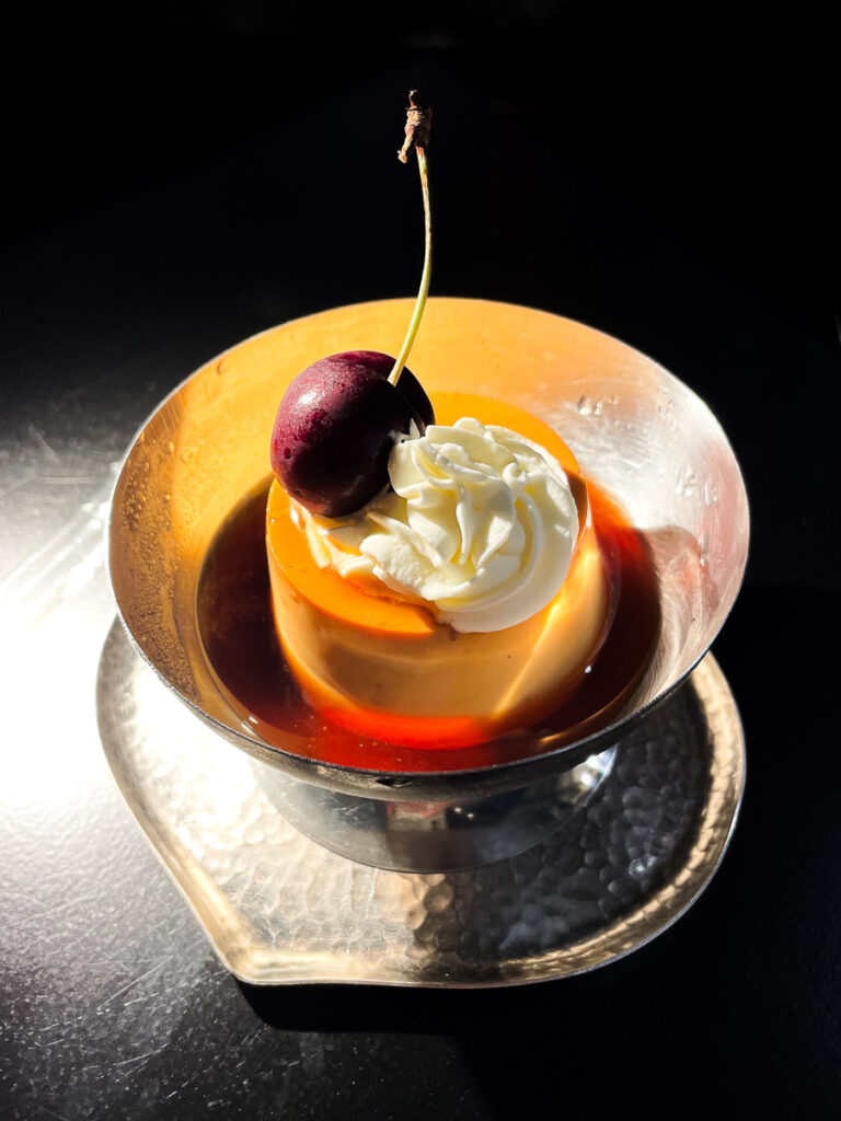 Pudding at Grow Tea.studio in Bangkok, placed under a sigle warm light source at the table.