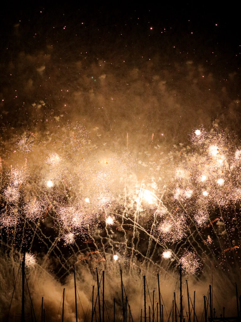 Countless small fireworks over a marina in Okinawa, creating a majestic festive view.