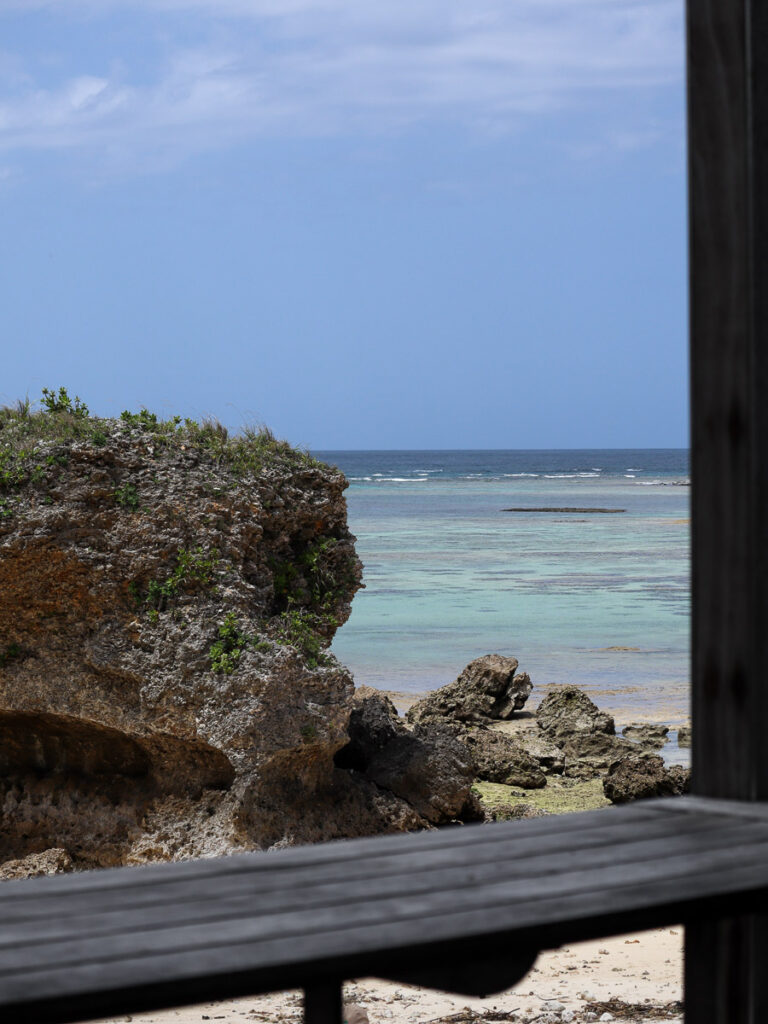 A terrace at Banta cafe in Okinawa. Sitting on a wooden deck looking out to the rocks formations and the island sea.