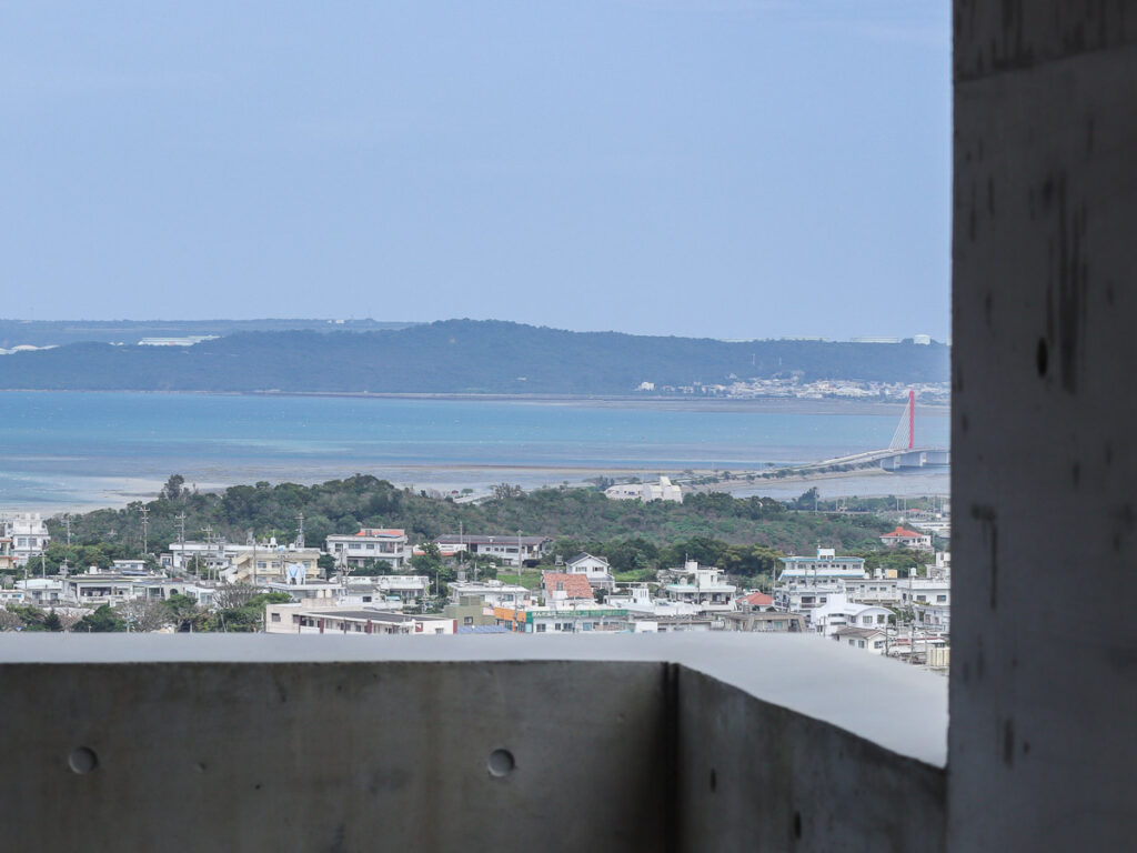 A view from a building in Uruma, looking out to the seaside city. In the distance you can also see a bridge connecting to Henza island.