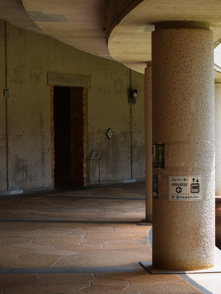 A round column structure at Tropical Dream Center in Okinawa. A gental light casting through the pillars giving a calm presence.