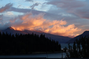 Sunset in Queenstown during december before new year, the orange light litup the back of the mountain and waves of cloud.