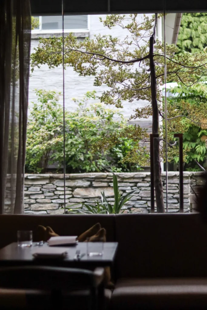The window side seat at Rātā Restaurant, a calming scenery through the window, lighting up the restaurant with natural light.