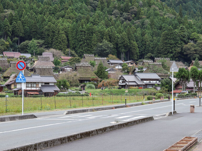 The road opposite of Kayabuki No Sato showing the village in full view, behind it the luscious green mountain.