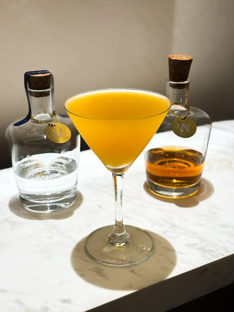 A homemade bright orange cocktail at the cocktail station in the room at Centara Reserve Samui.