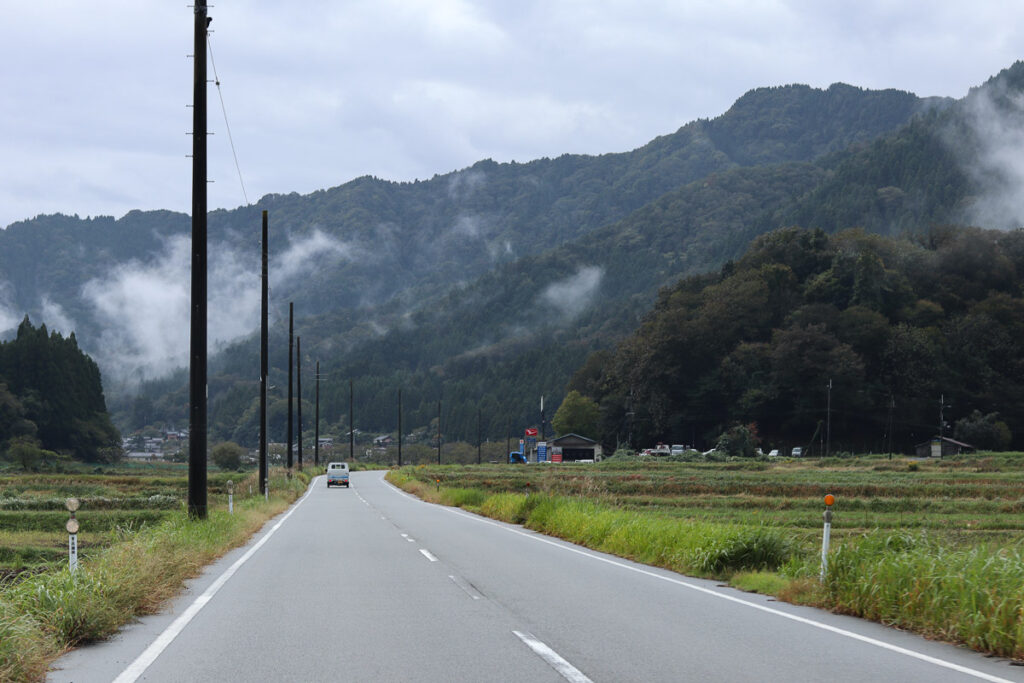 A peaceful road passing the mountains in rural Japan, a calm day after the rain.