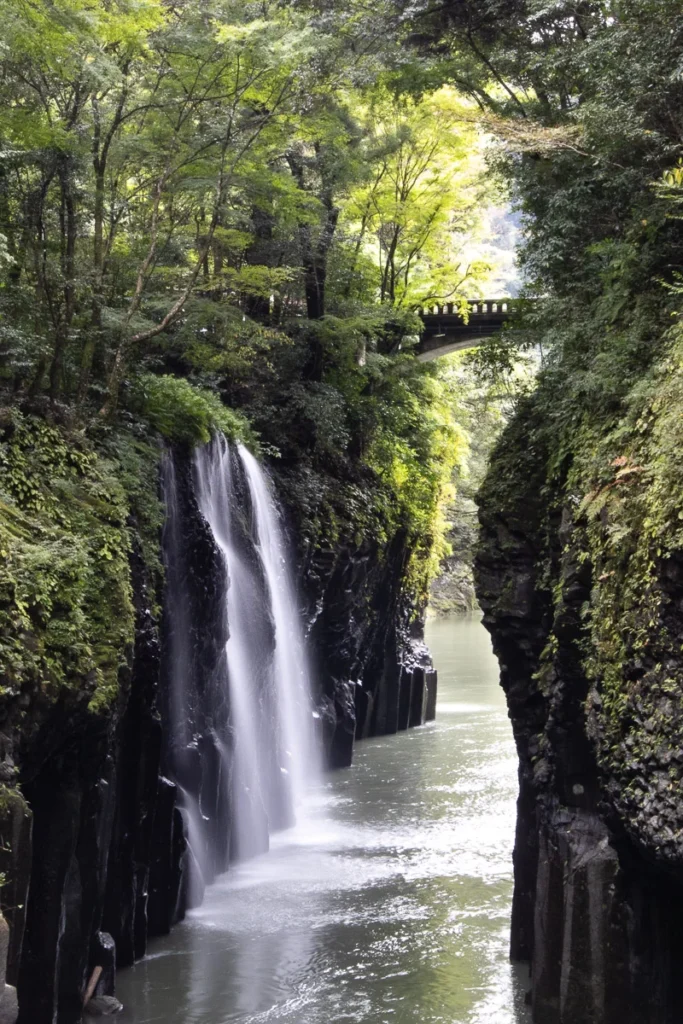 The incredible waterfalls at Takachiho gorge, an interesting flow of water inbetween rock formation amidst the green surrounding.