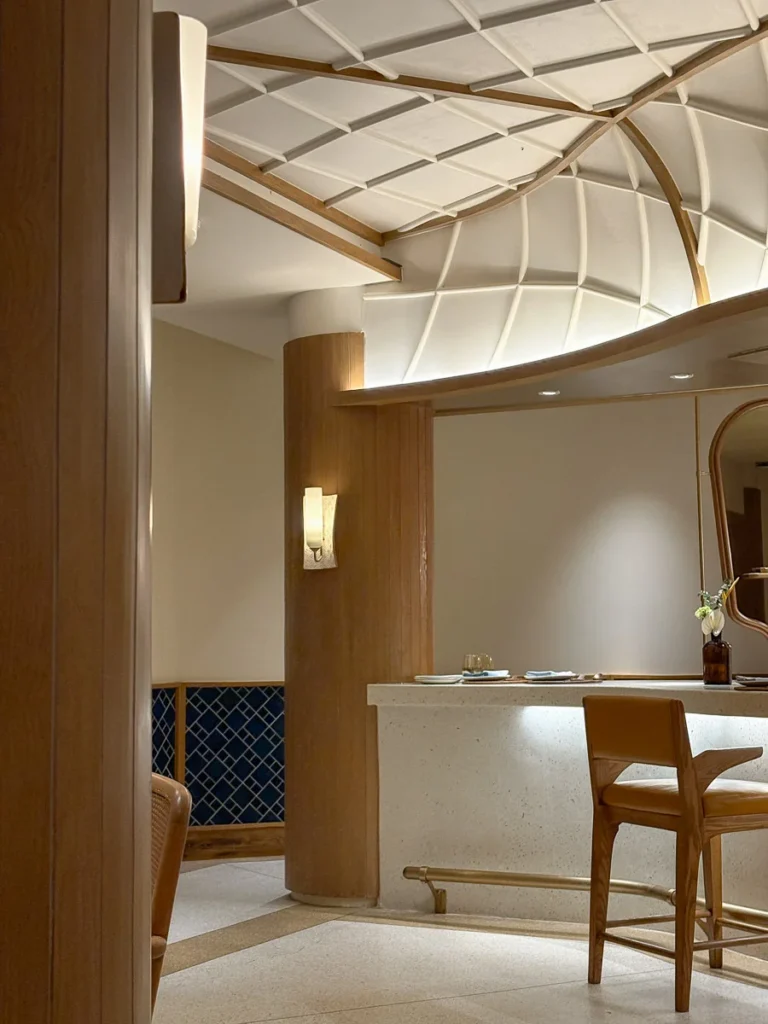 A modern restaurant Interior, whit color, wooden surfaces accent and warm light: the basic combination of modern luxury.