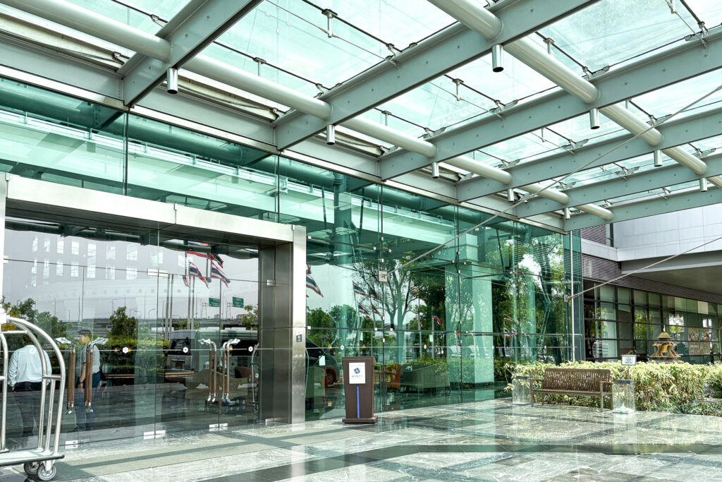 Hyatt Regency Bangkok Suvarnabhumi front entrance decorated with glass facade.