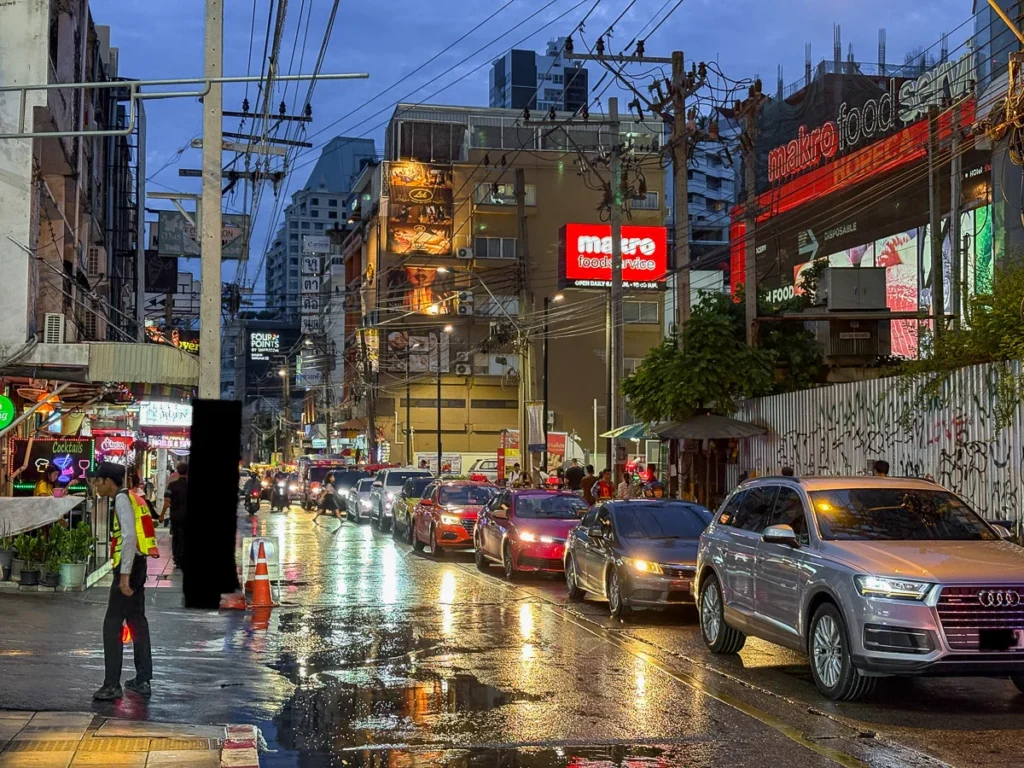 The busling street of Sukhumvit 22 as the night life slowly begins, combined with a long line of traffic jam.