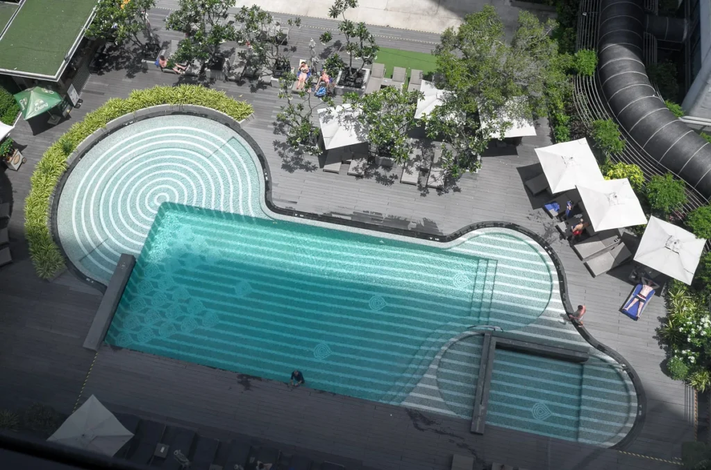 The pool facility at Marriott Marquis Queen's Park. An hour in the afternoon as the sun cast a shadow of the building providing a shade for half of the pool area.