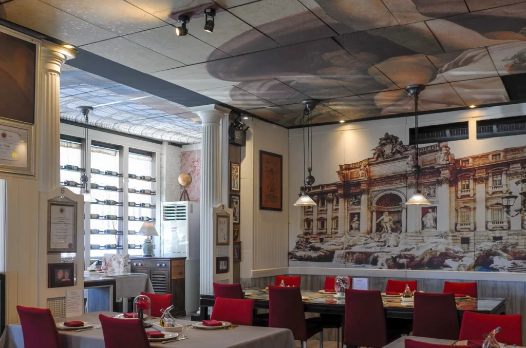 The dining room of Gian's Italian Restaurant in Pattaya, a well decorated interior surrounded by images, even the roof.