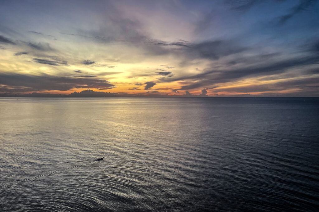 The first light of the day from Hua Hin, as a small fishing boat leaves the dock.