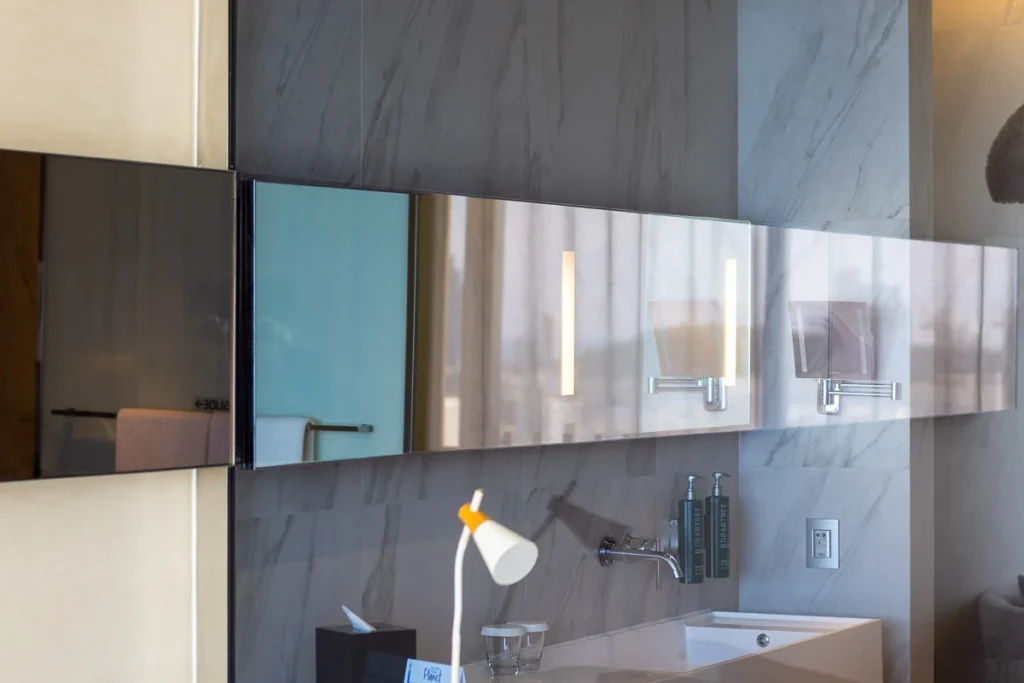 A seemingly connecting mirror spanning from the bathroom to the end of the room, a noteworthy element of design at Hilton Pattaya.