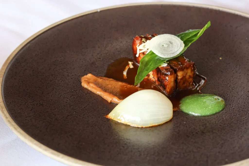 Lake Ohau Wagyu Short Rib coated in rich black glace served at Mudbrick Vineyard & Restaurant, a one Michelin star diner.