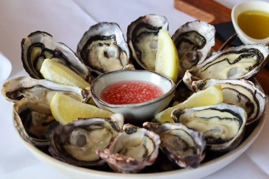 Fresh Waiheke Market Oysters served at Mudbrick Vineyard & Restaurant along with lemon slices and vinegar.