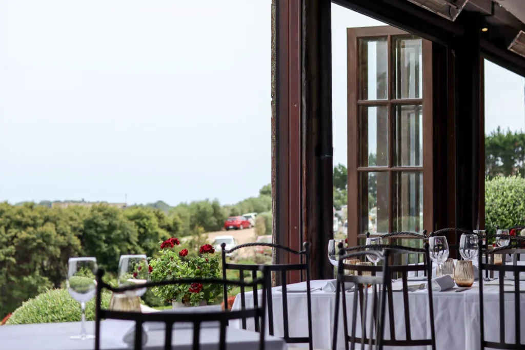 The dining room with open windows during summer on Waiheke Island, one of the most romantic places to dine in the country, Mudbrick Restaurant.