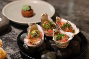 Fresh oysters and starter on the table at Rata Restaurant in Queenstown, an elevated dining experience.