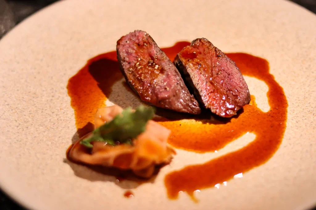 A very well cooked, pink in the center, venison served at Rata Restaurant in Queenstown, a one Michelin star restaurant.