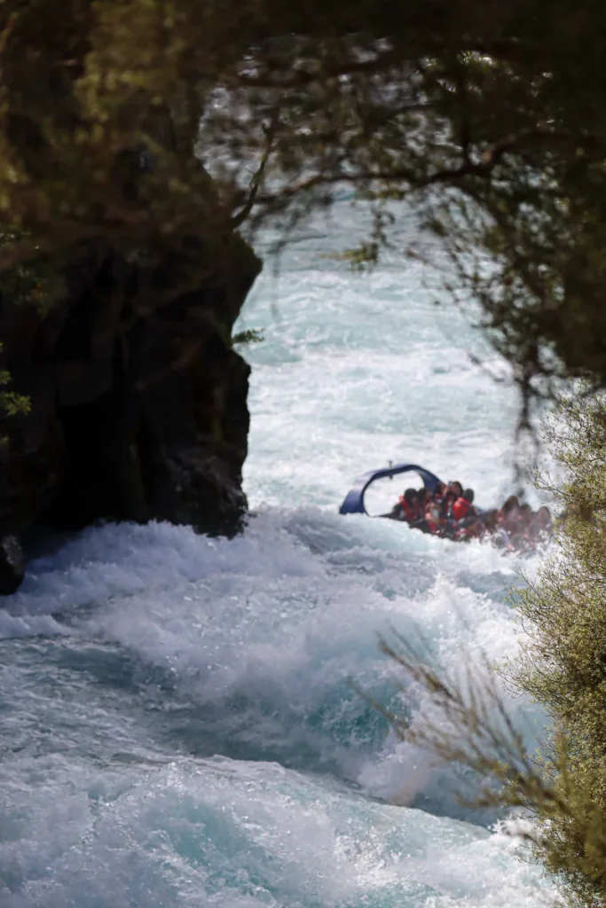 Dramatic waves and bright light blue color of the water at Huka Falls, the moment before it drops down into a waterfall.