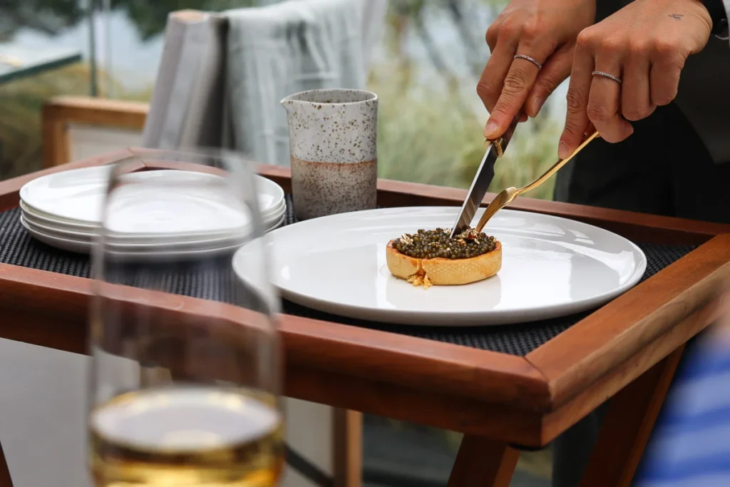 Signature Langoustine tart topped with caviar being devided table side for sharing, the pinnacle of luxury dining.