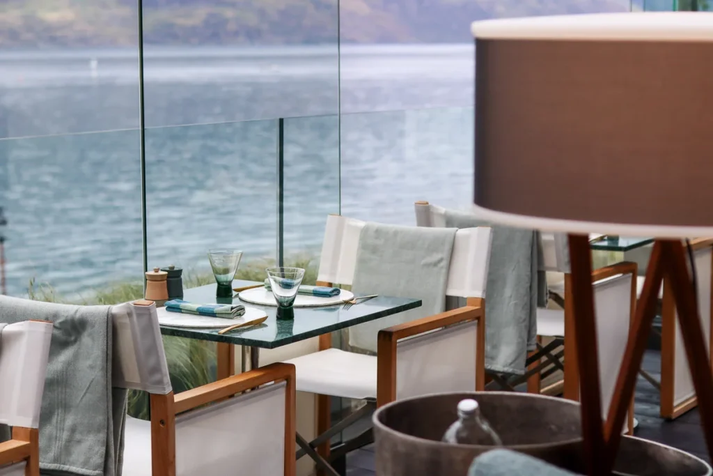 Dining table, cloth and accents color that match the view of Lake Wakatipu outside the window at Terrace by Roki Collection.