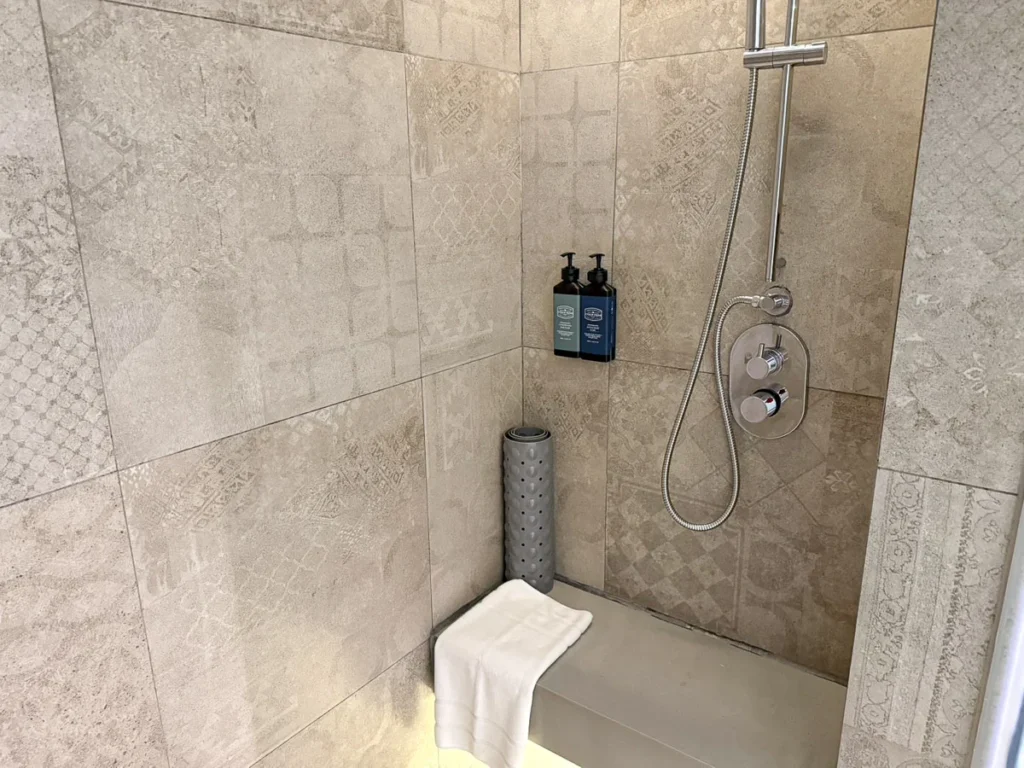 A shower with textured tiles, a simple yet elevated shower room design at U Nimman.