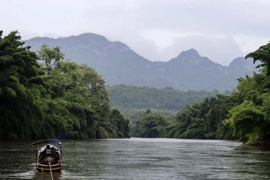 Cruising along Khwae Noi River during a light rain